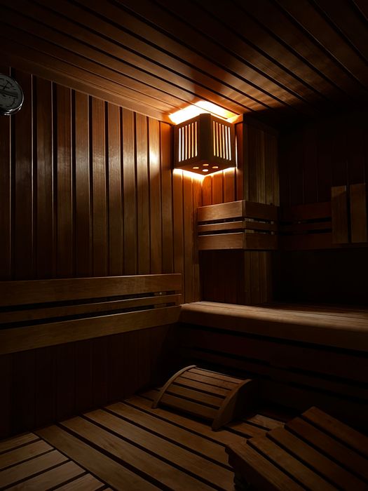 Inviting sauna room with wooden interiors and ambient lighting. Perfect for relaxation.